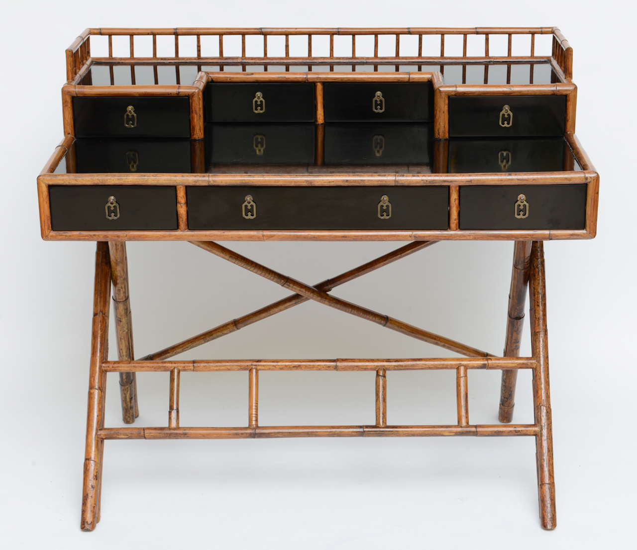 SOLD  In an Anglo-Japanese style springing from the Brighton Pavilion, this black painted and bamboo chinoiserie desk or writing table is quite charming with its gallery of small drawers and bamboo gallery, bamboo edges and elaborate base.  Very